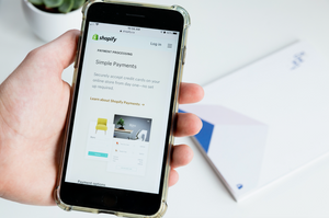 Shopify Payments – Smartphone in der Hand