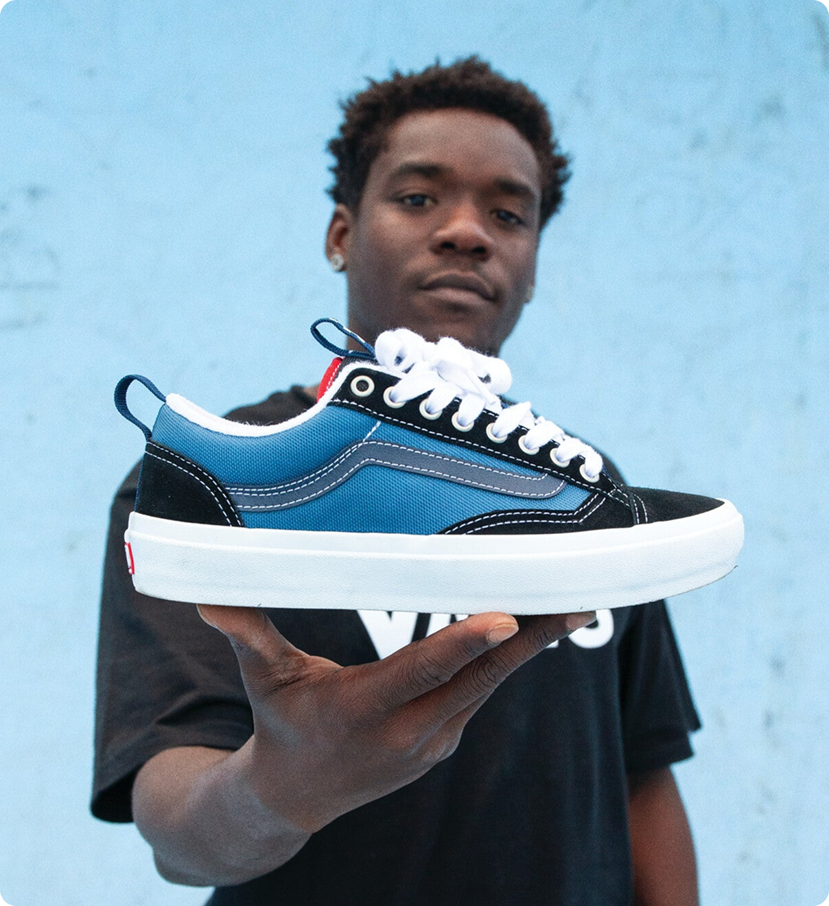 TITUS: Mann im Hintergrund, der einen blauen Sneaker in die Kamera hält